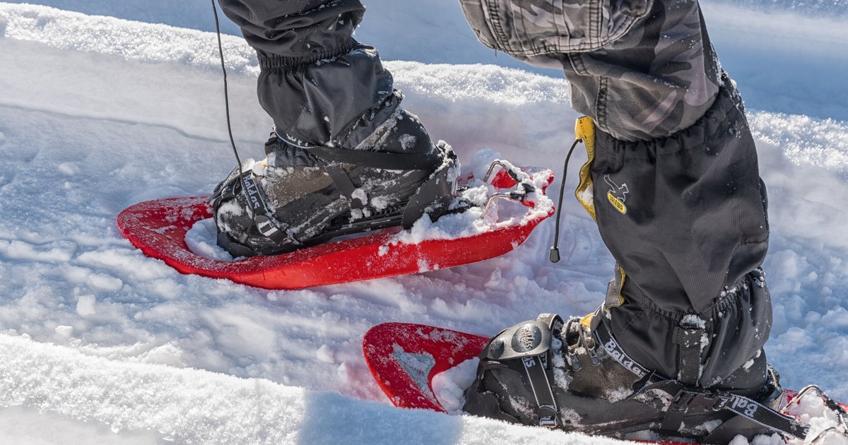 Close-up of red snowshoes on a snowy trail in the Italian Alps
